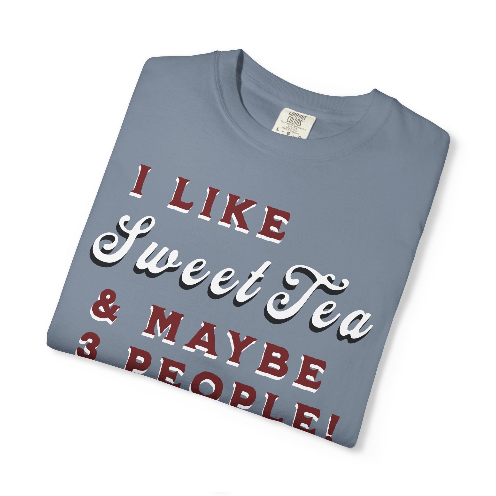 Folded blue t-shirt with text 'I LIKE Sweet Tea & MAYBE 3 PEOPLE!' on a white background