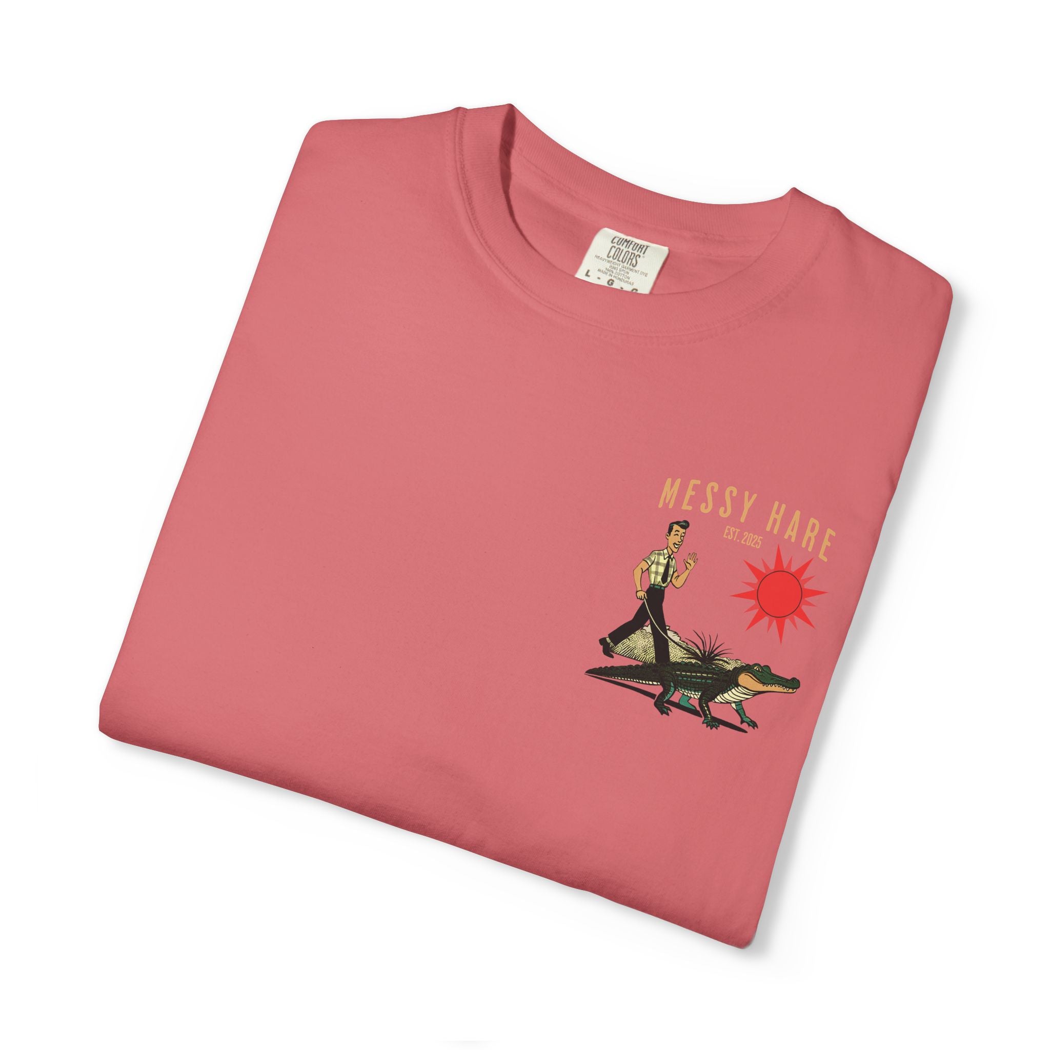 Folded pink t-shirt with 'Messy Hare' graphic design on a white background