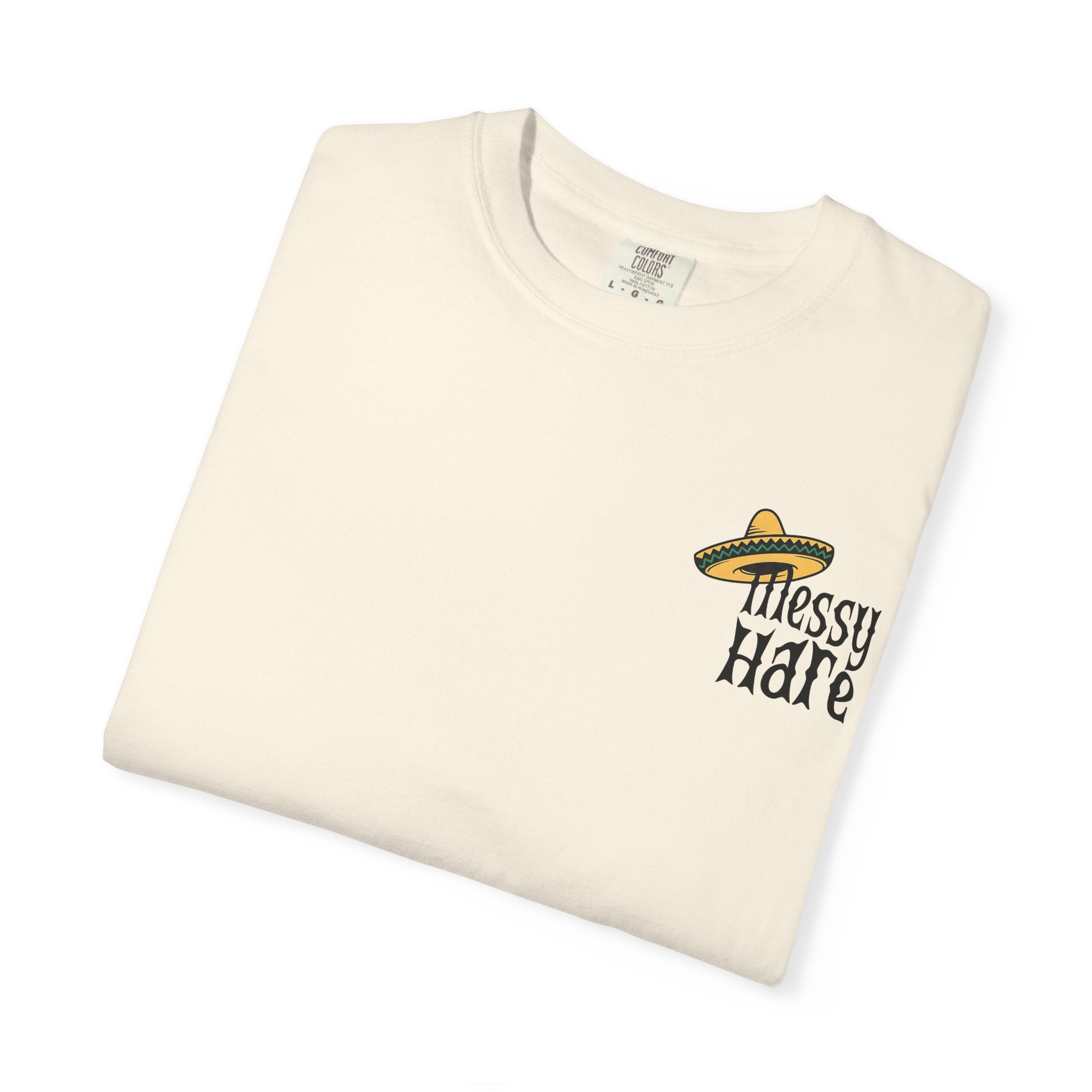 Folded cream-colored t-shirt with 'Messy Hare' text and sombrero graphic on a white background