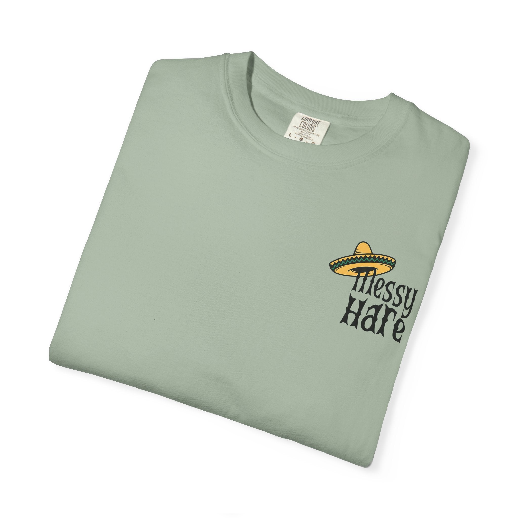 Folded light green t-shirt with 'Messy Hare' logo on a white background