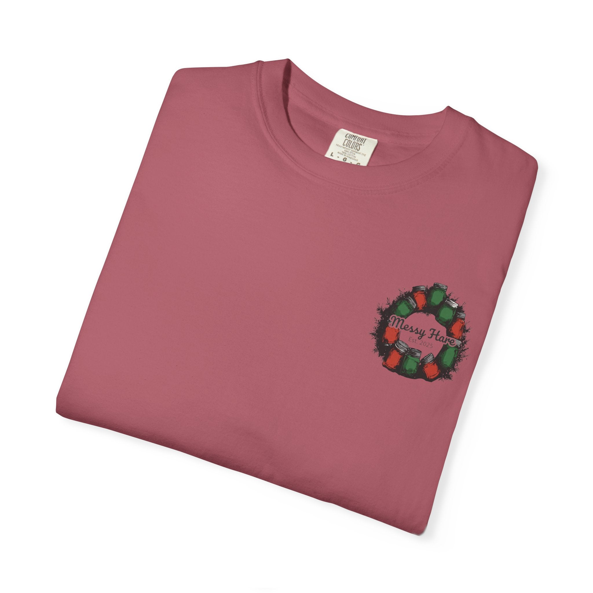 Folded maroon t-shirt with a Christmas wreath design on a white background