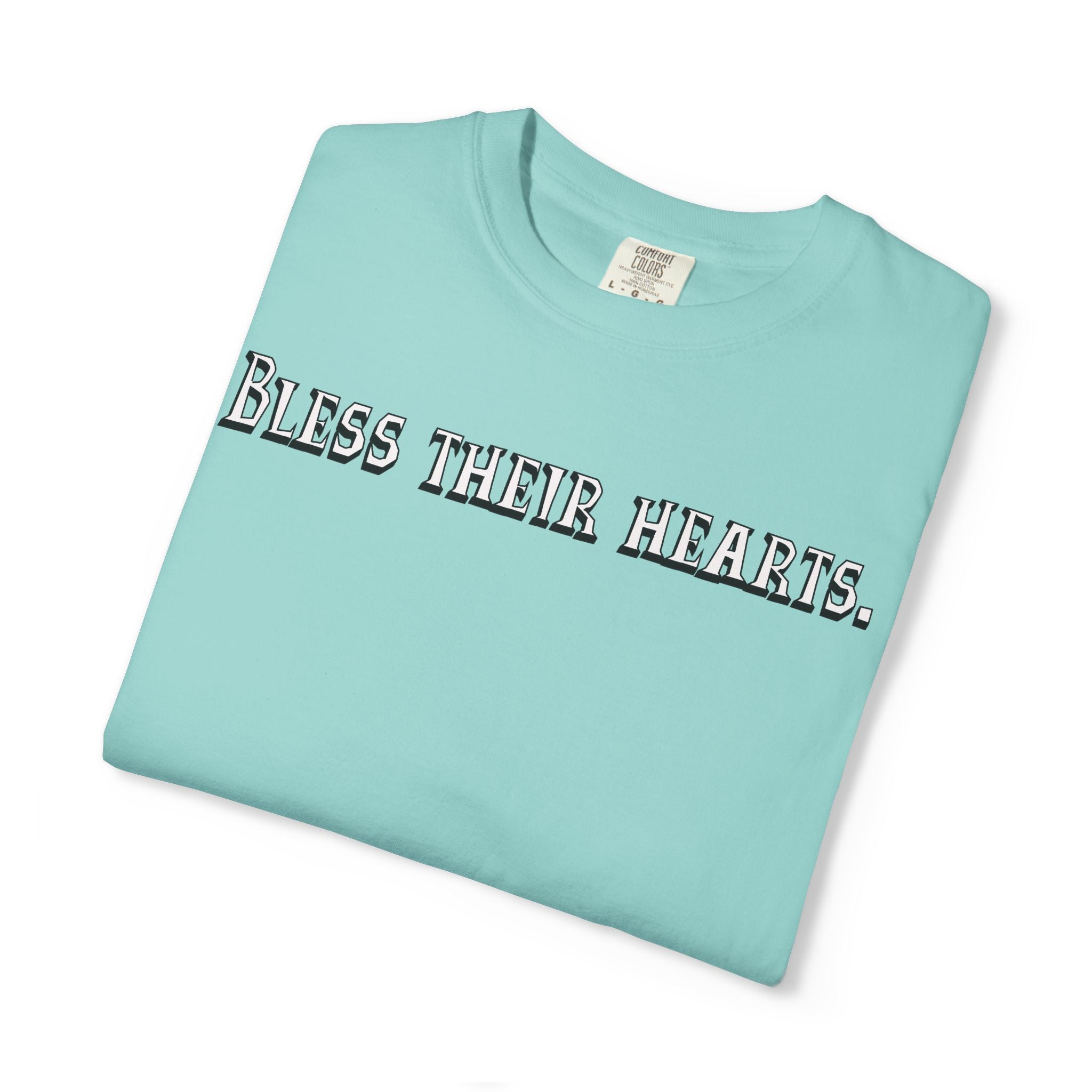 Folded light blue t-shirt with 'Bless their hearts.' text on a white background