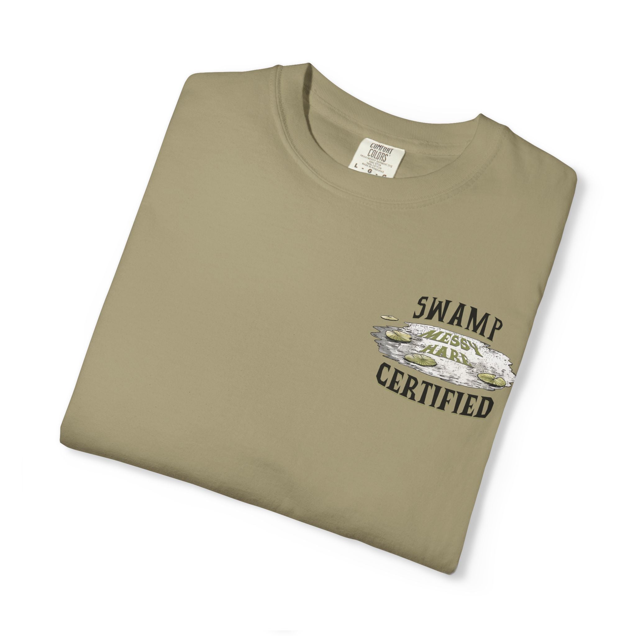 Folded khaki t-shirt with 'Swamp Certified' text and graphic on a white background