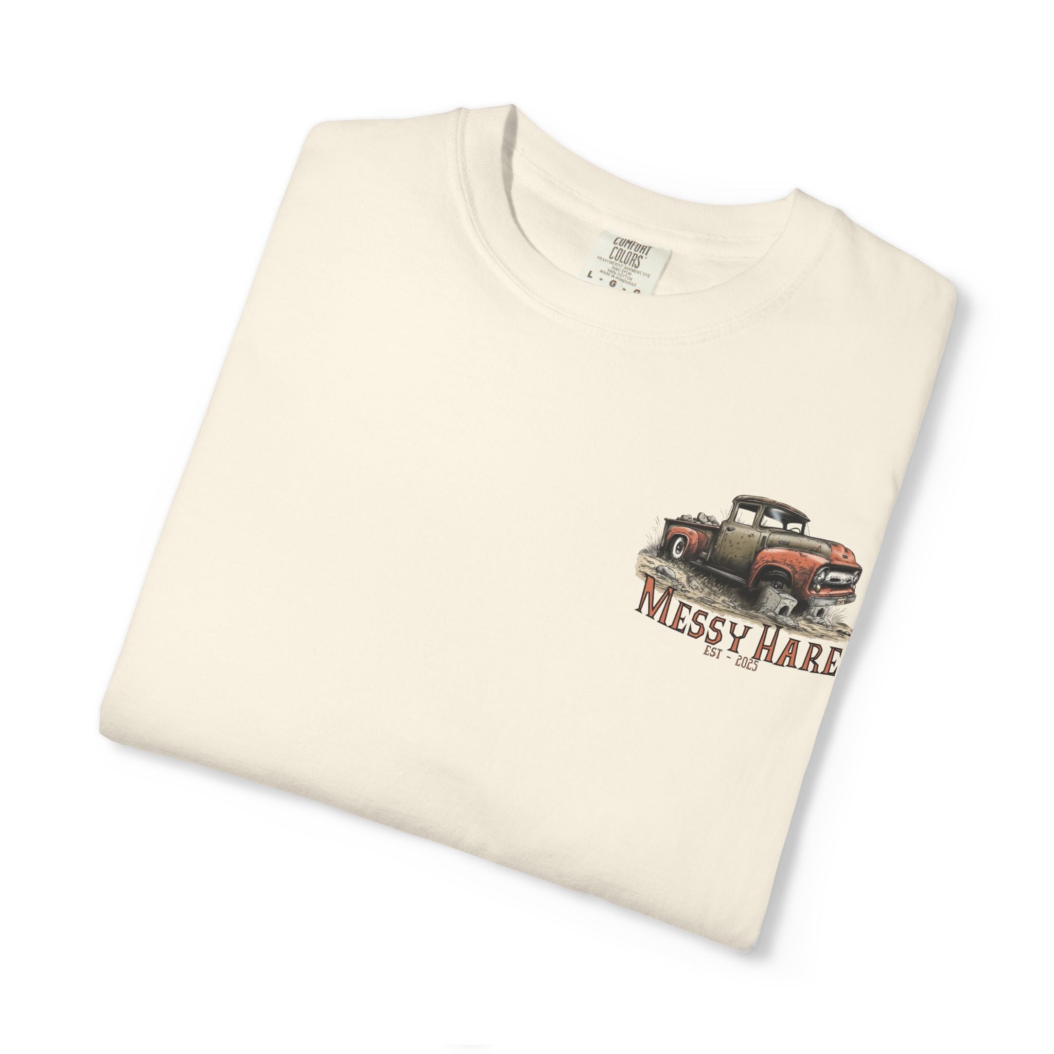 Folded cream-colored t-shirt with a graphic of a truck and 'Messy Hare' text on a white background