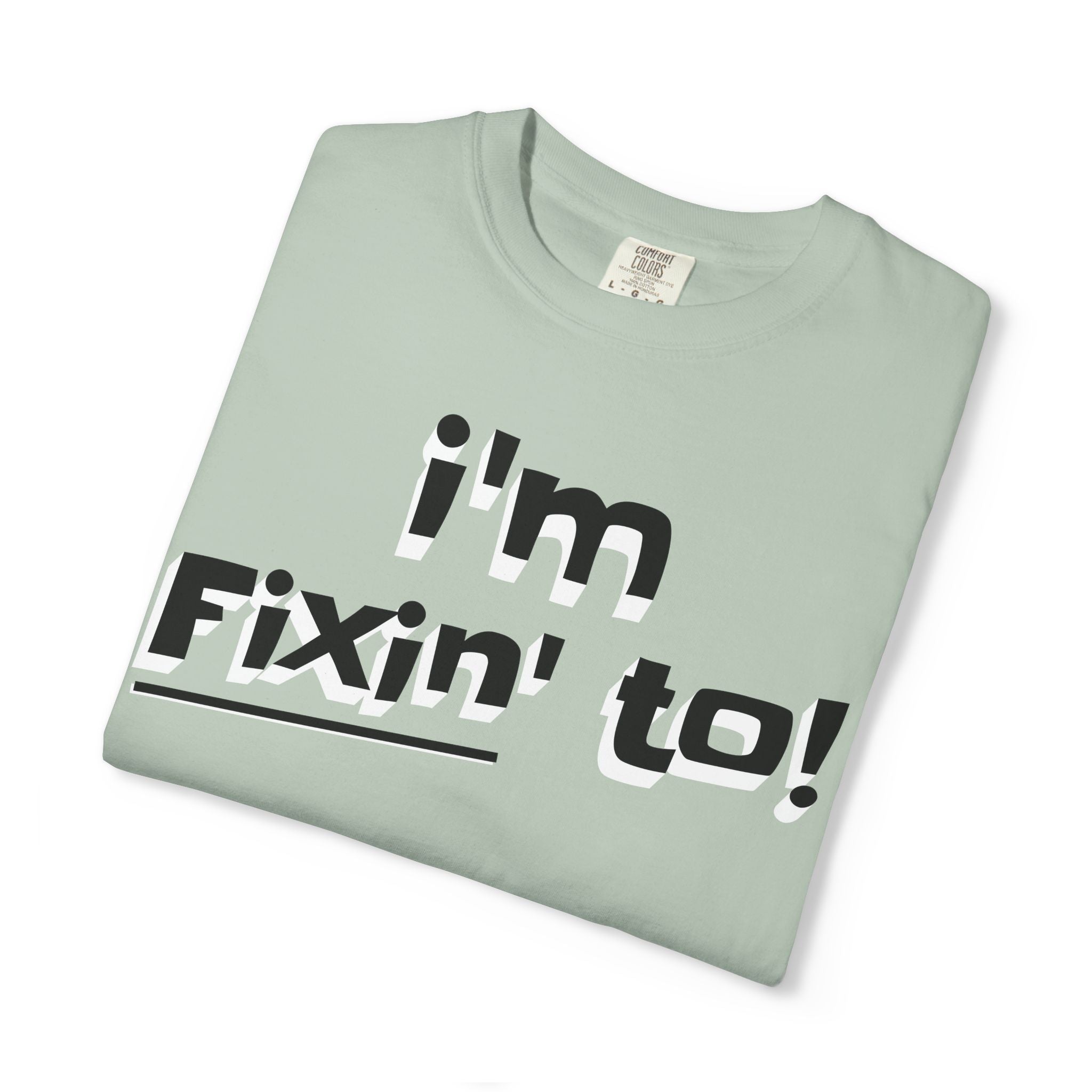 Folded light green t-shirt with 'i'm Fixin' to!' text on a white background