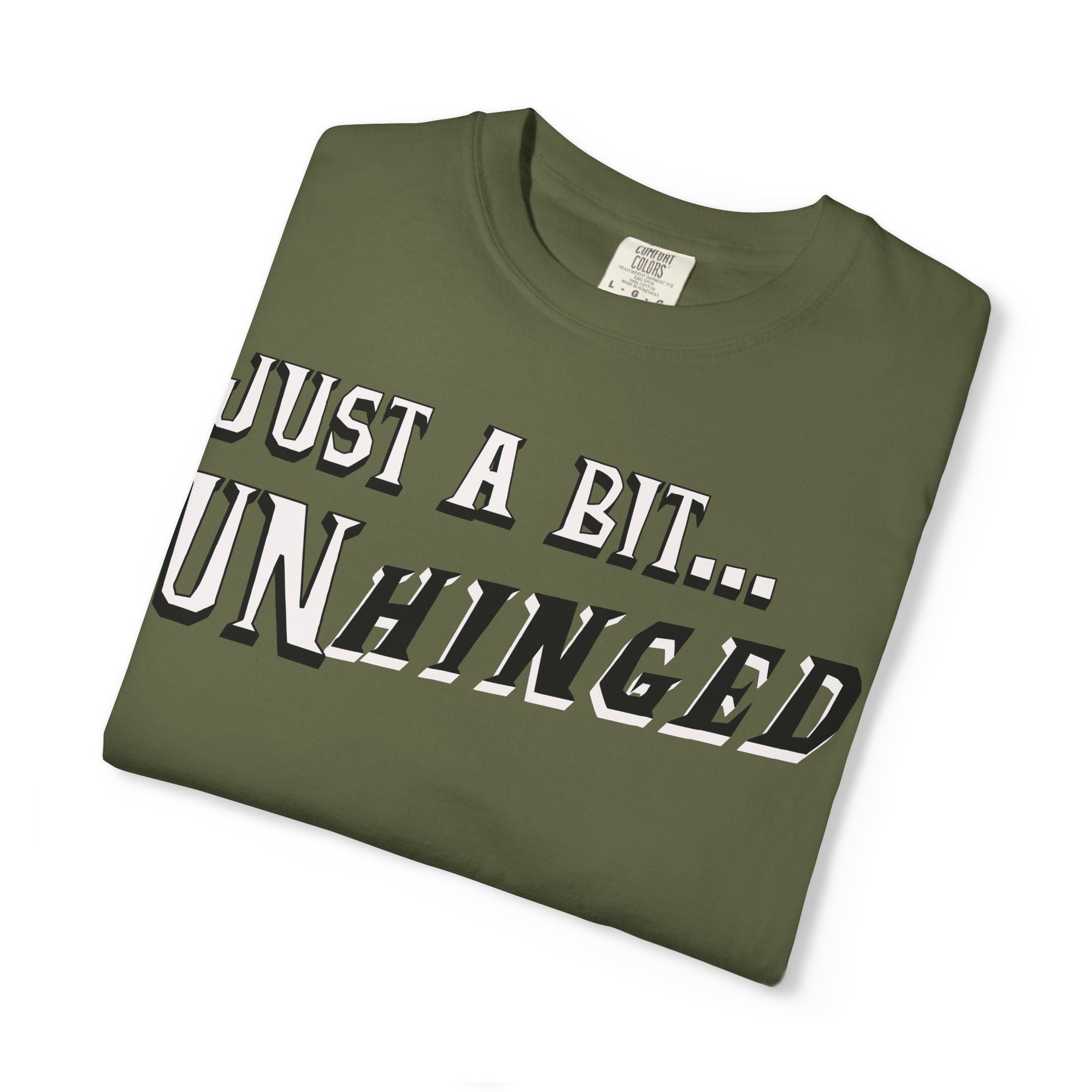 Folded green t-shirt with text 'JUST A BIT... UNHINGED' on a white background