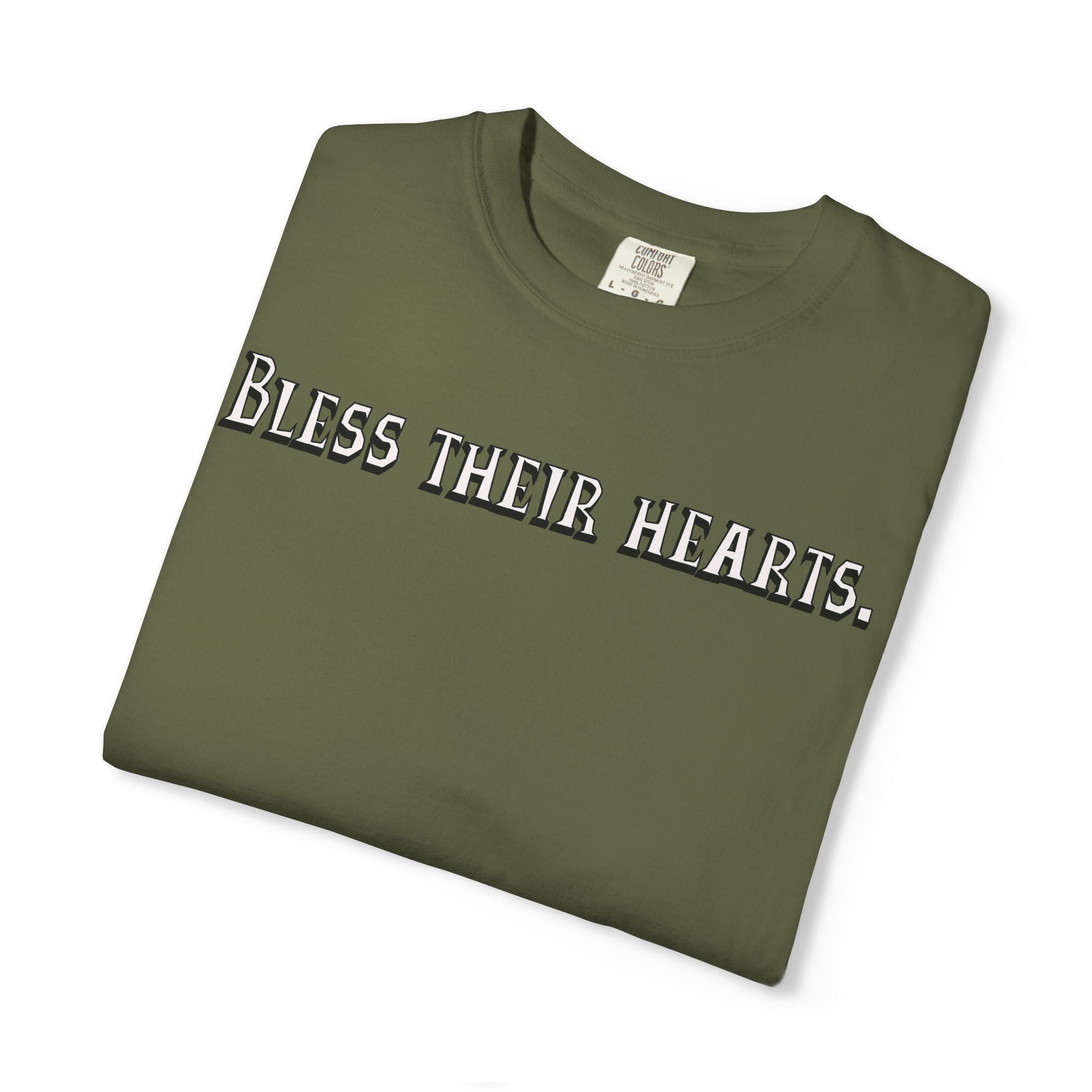 Folded green t-shirt with 'Bless their hearts.' text on a white background