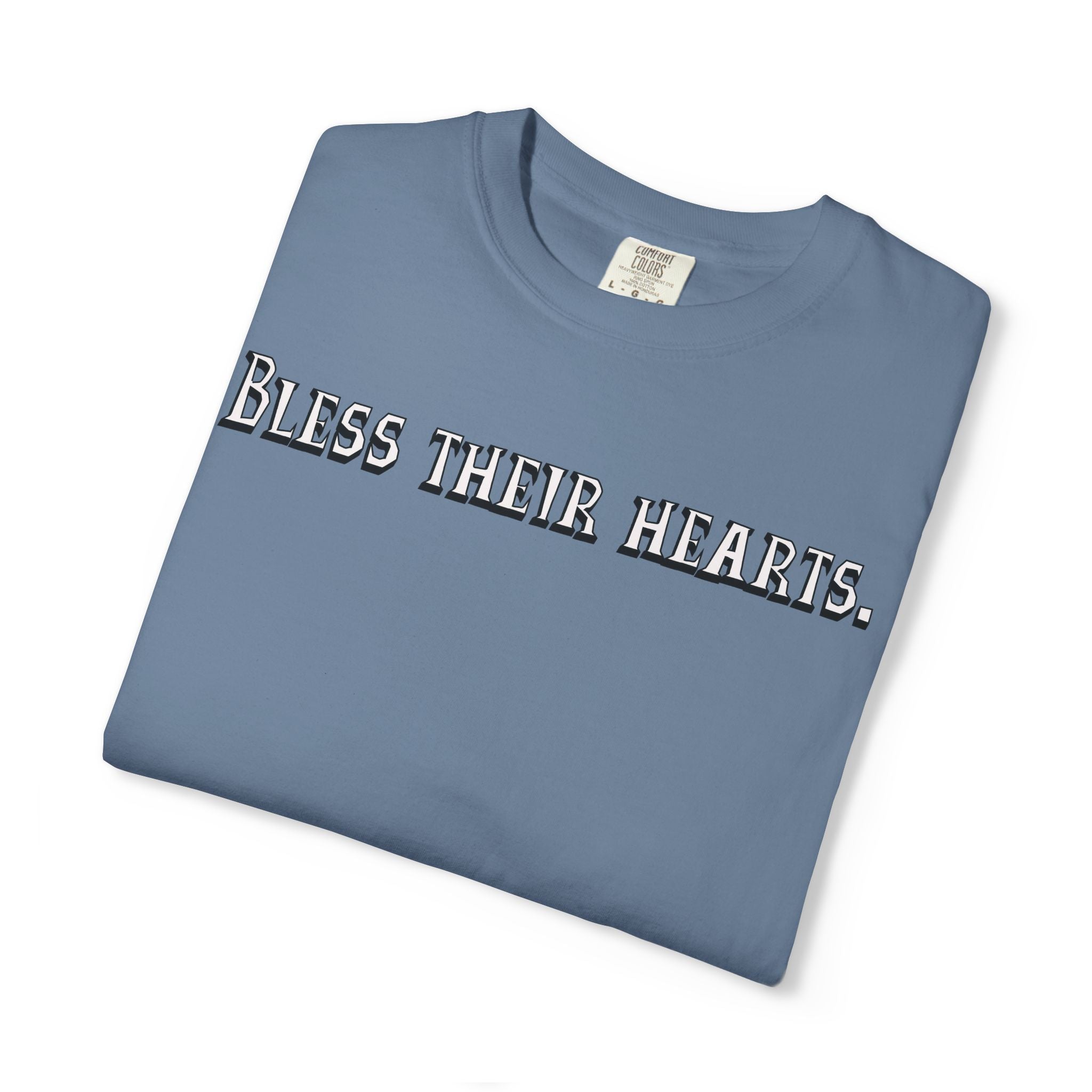 Folded blue t-shirt with 'Bless their hearts.' text on a white background