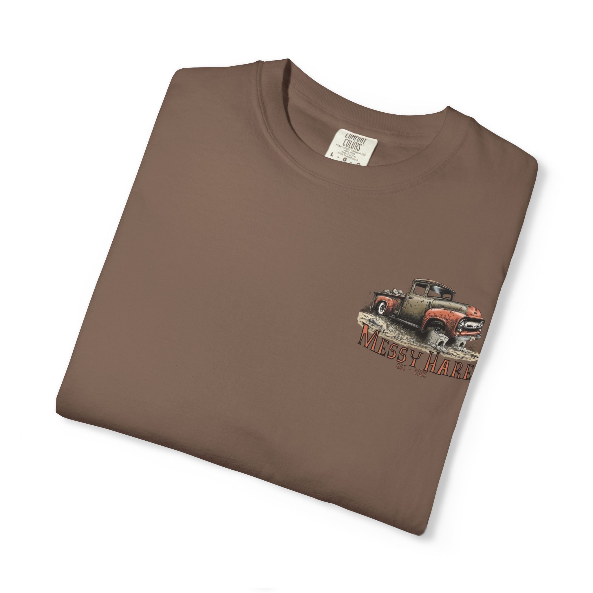 Folded brown t-shirt with a graphic of an old truck and 'Messy Hare' text on a white background