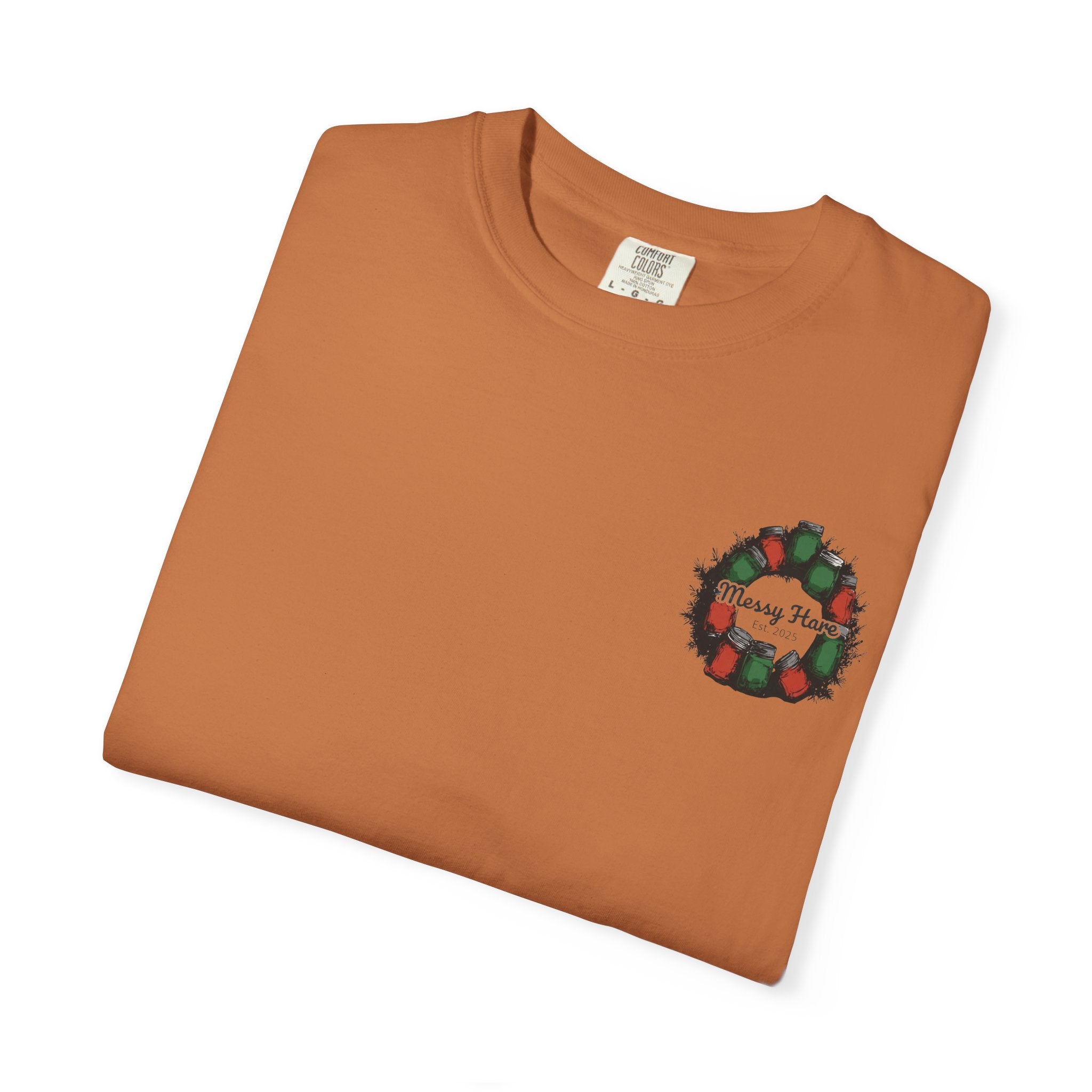 Folded brown t-shirt with a Christmas wreath design on a white background