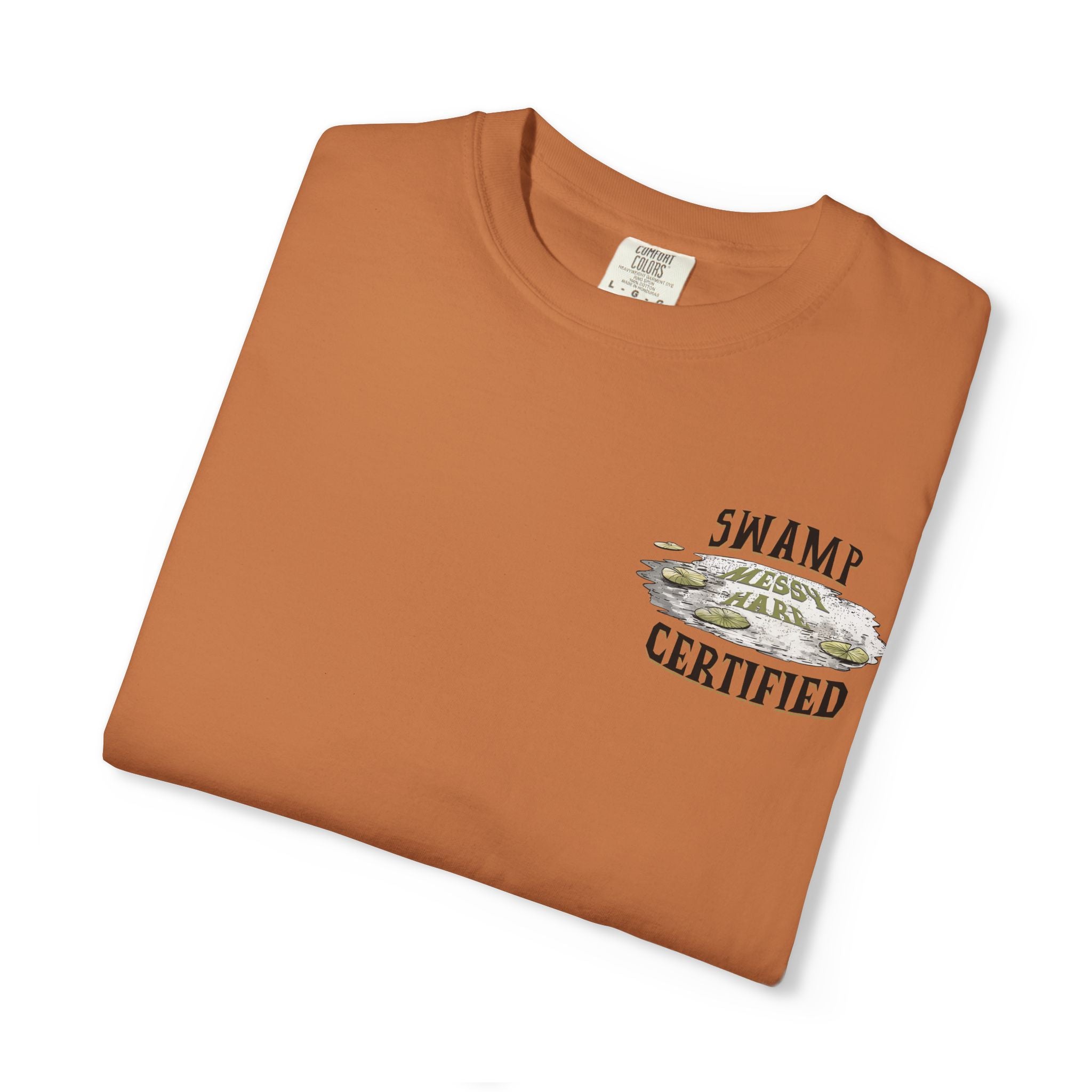 Folded brown t-shirt with 'Swamp Certified' graphic on a white background