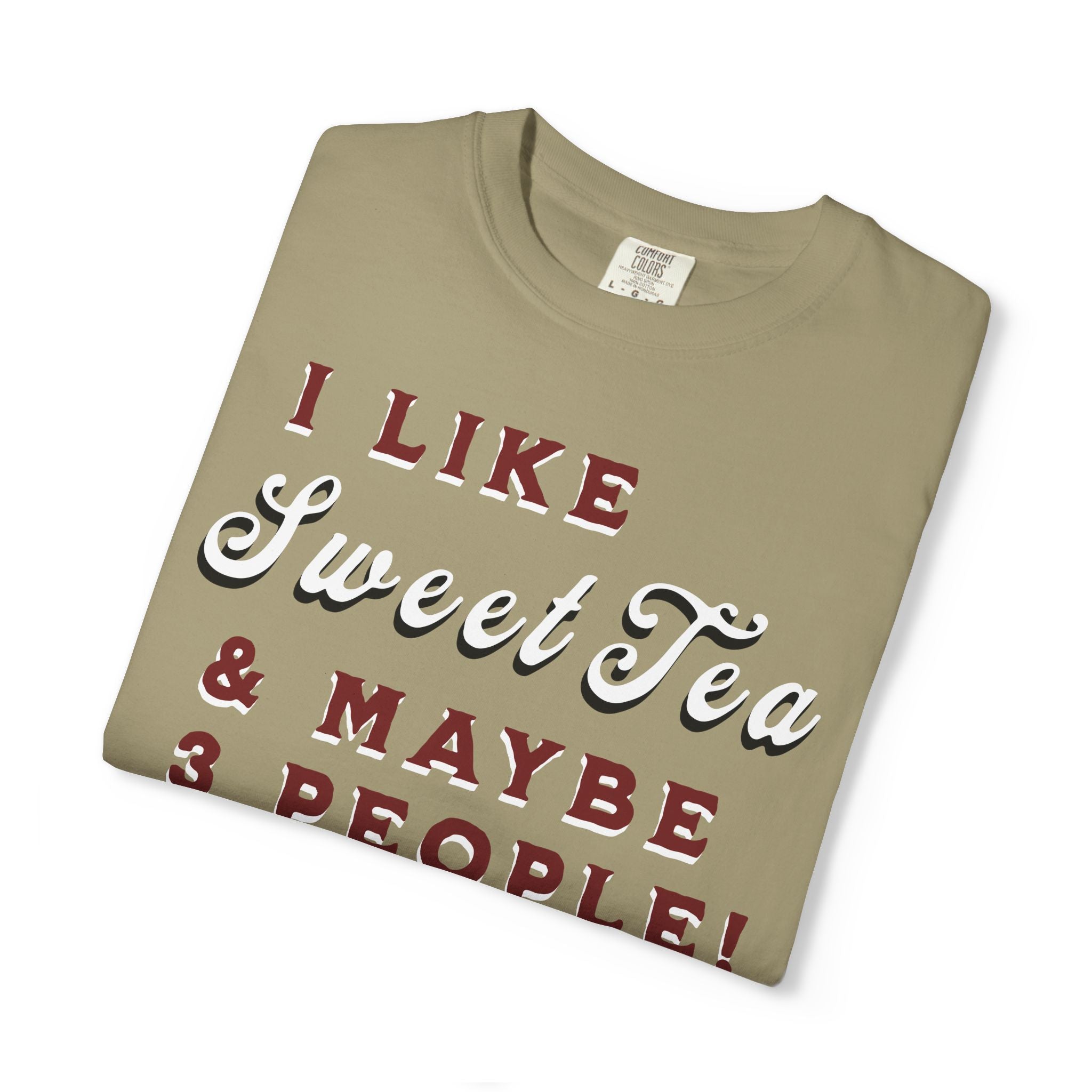 Folded beige t-shirt with text 'I LIKE Sweet Tea & MAYBE 3 PEOPLE!' on a white background
