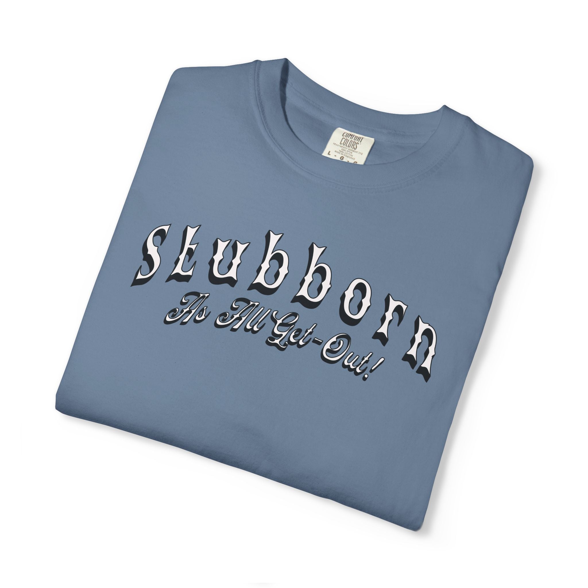Folded blue t-shirt with 'Stubborn The Hell Got Out' text on a white background