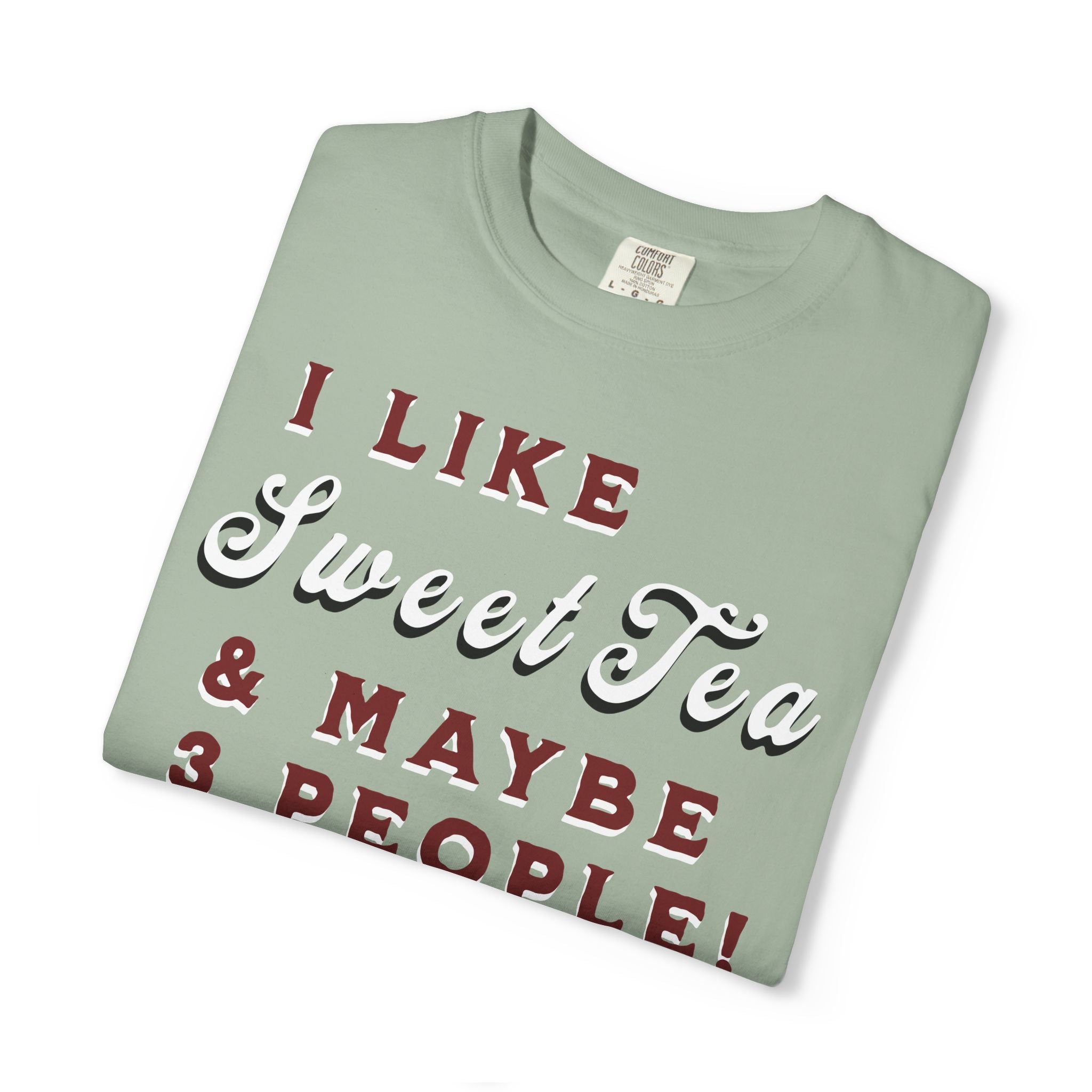 Folded light green t-shirt with text 'I LIKE Sweet Tea & MAYBE 3 PEOPLE!' on a white background
