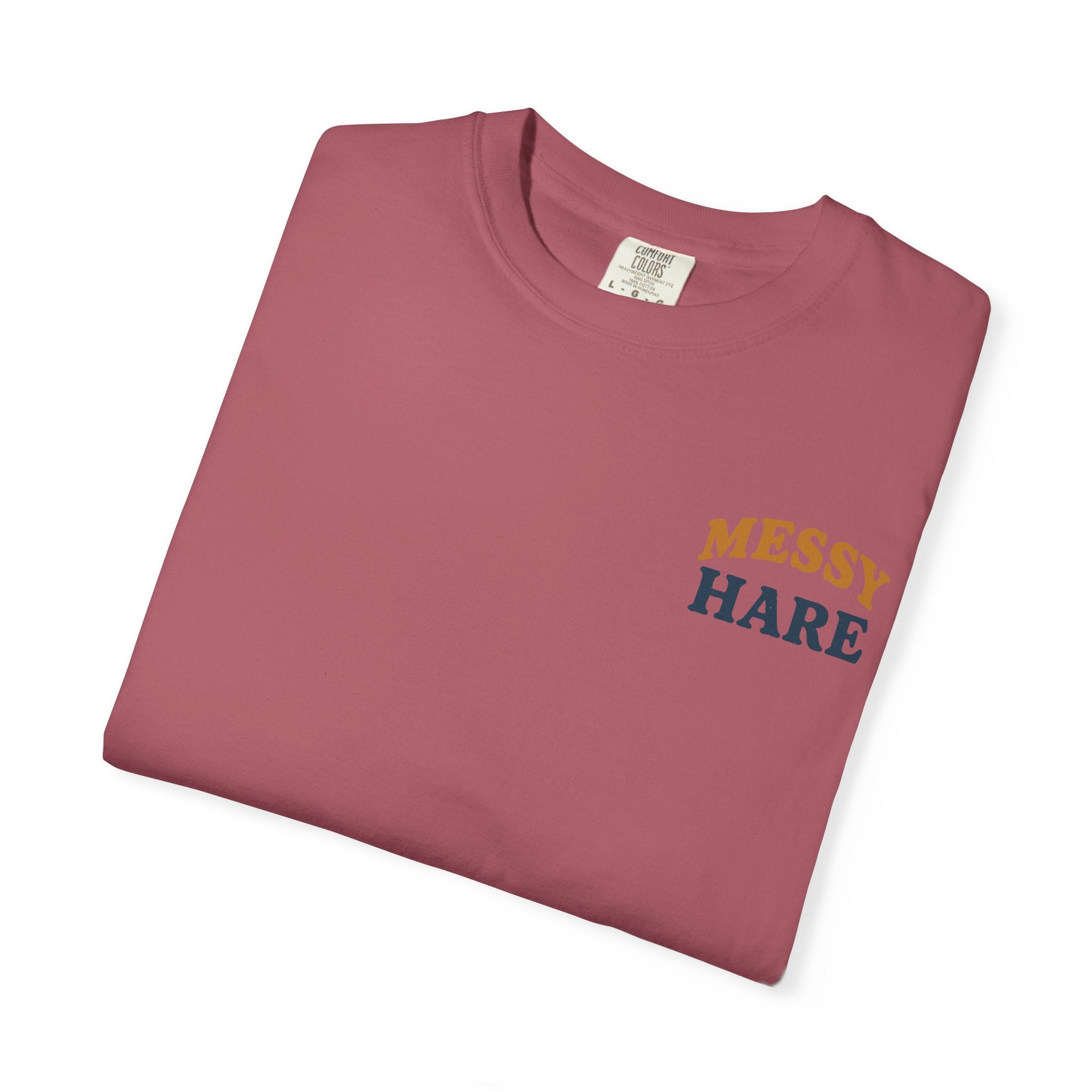 Folded maroon t-shirt with 'MESSEY HARE' text on a white background