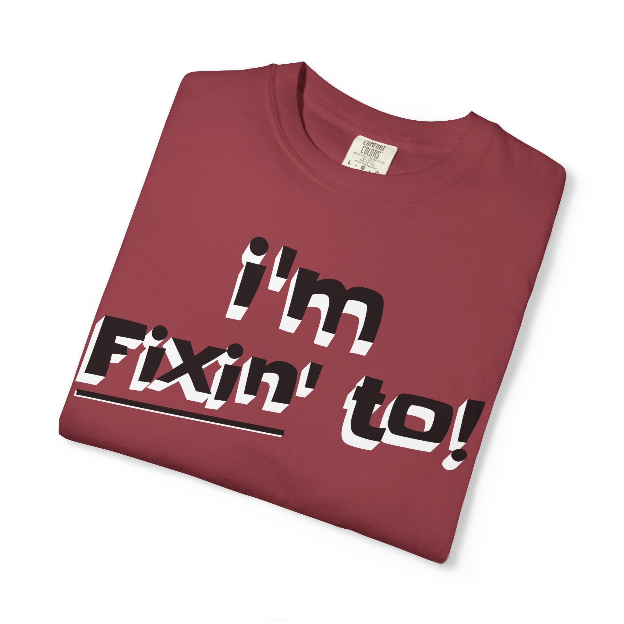 Folded maroon t-shirt with 'i'm Fixin' to!' text on a white background