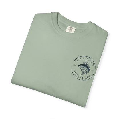 Folded green t-shirt with a logo and text on a white background