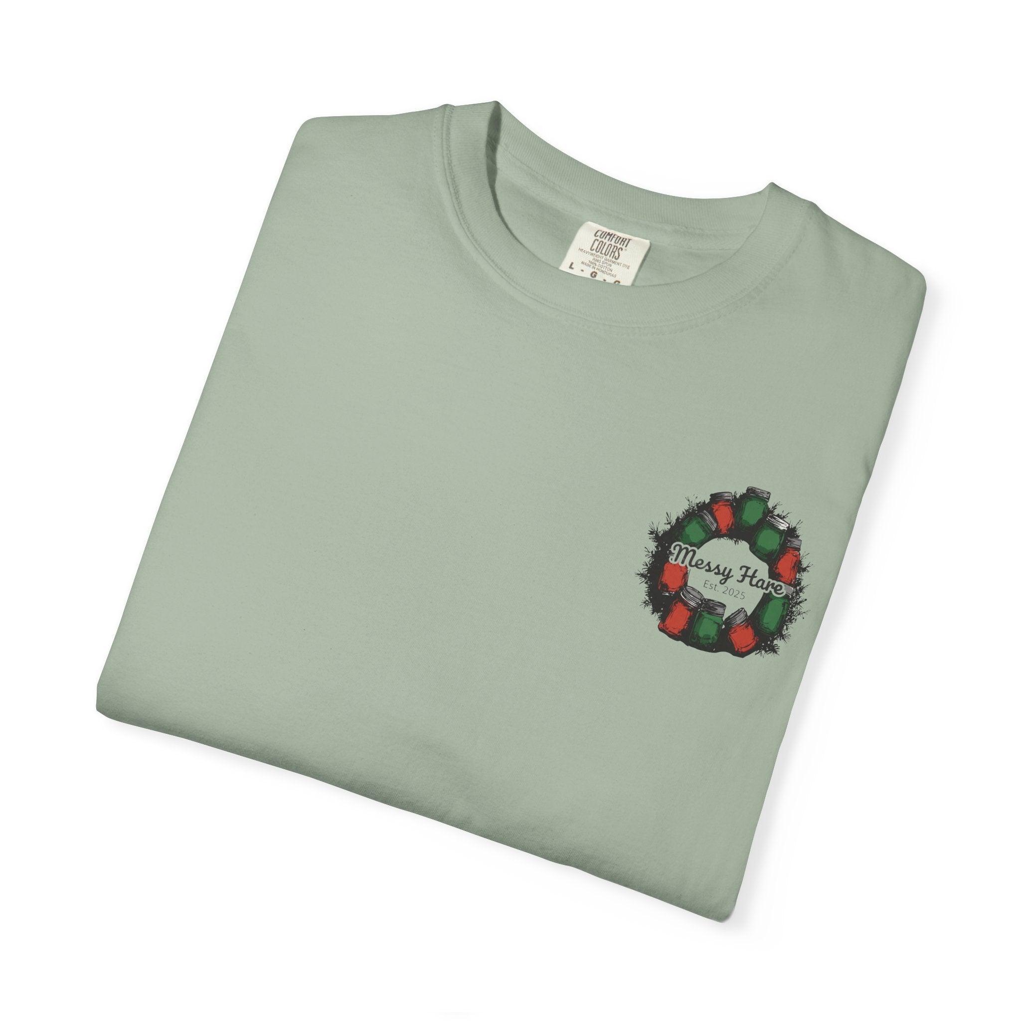 Folded light green t-shirt with a Christmas wreath design on a white background