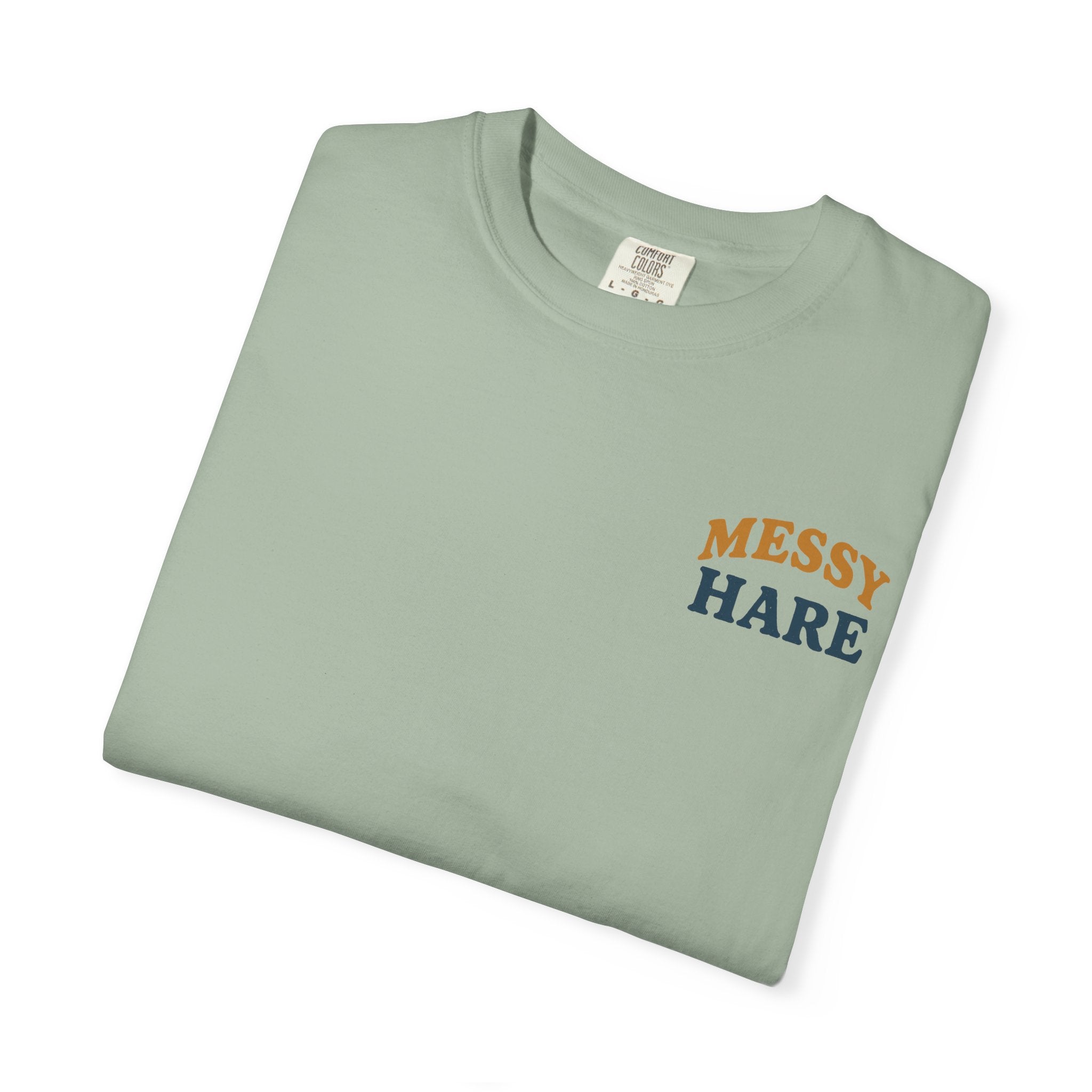 Folded light green t-shirt with 'Messy Hare' text on a white background