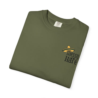 Folded green t-shirt with 'Messy Hare' logo on a white background