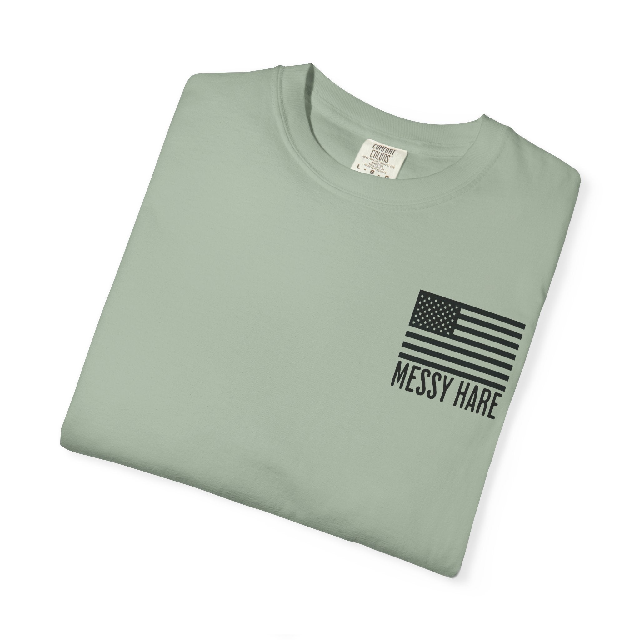 Folded light green t-shirt with American flag and 'Messy Hare' text on a white background