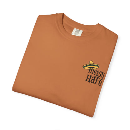 Folded brown t-shirt with 'Messy Hare' text and sombrero graphic on a white background