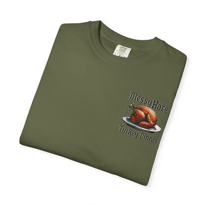 Folded green t-shirt with a graphic of a roasted turkey and text on a white background