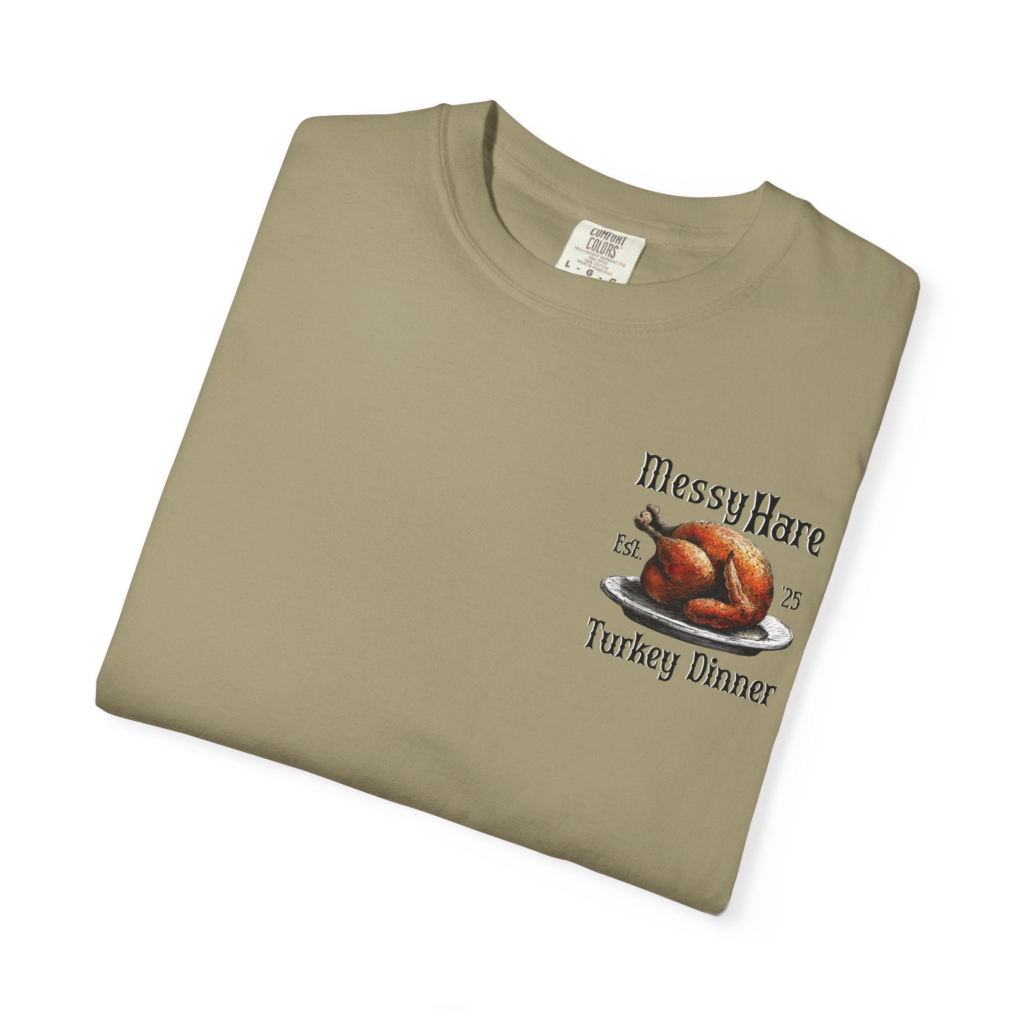 Folded khaki t-shirt with 'Messy Hare' and 'Turkey Dinner' graphic on a white background