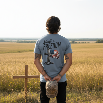 Man wearing a t-shirt with 'Faith & Freedom' design in a field